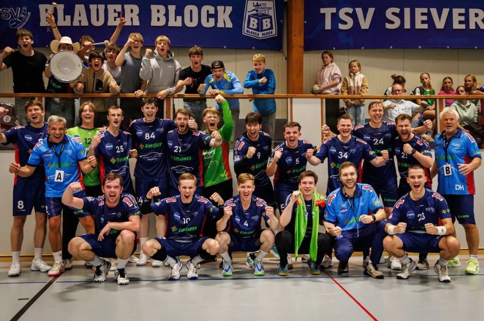 Mannschaft des TSV Sieverstedt feiert mit den Fans vom Blauen Block